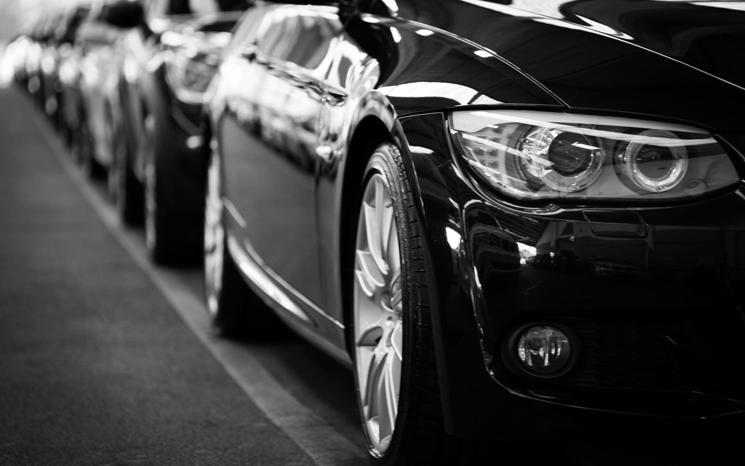 A line of black chauffeur-driven cars waiting in order for a coordinated movement