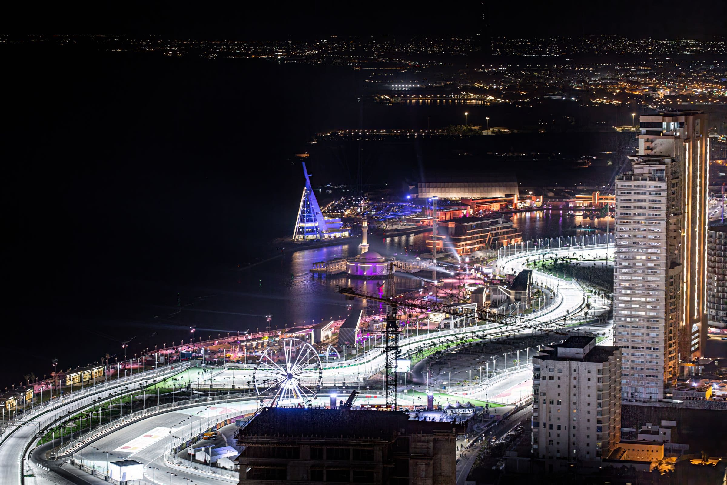 The Jeddah Corniche lit at night, a chauffeured car waiting through an evening out