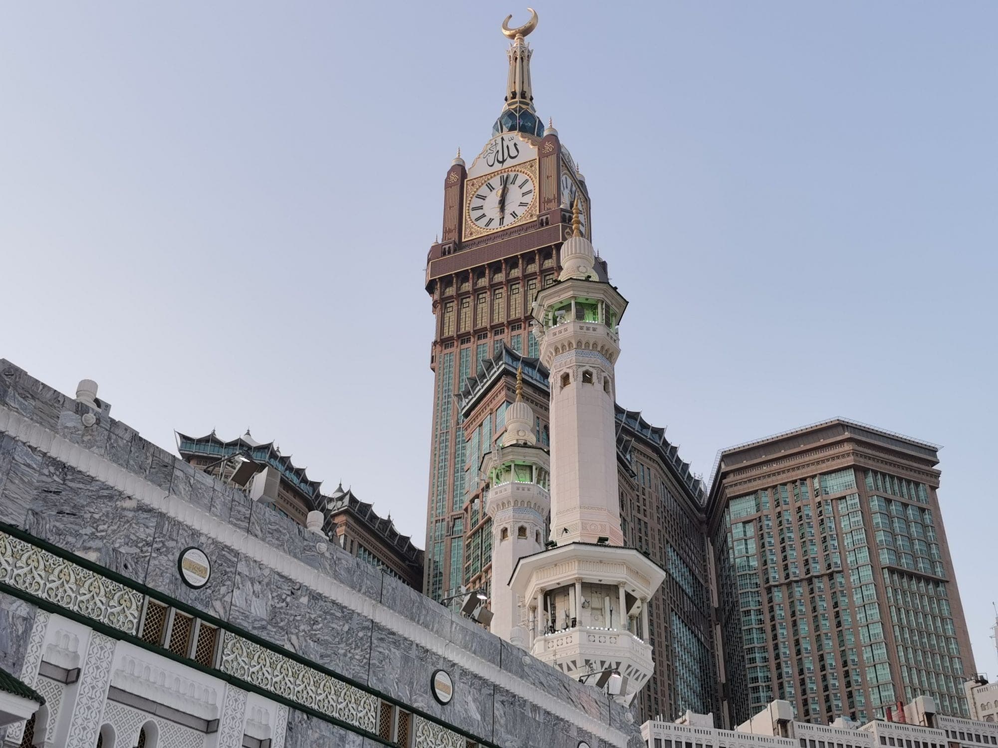 The Abraj Al Bait clock tower over the marble colonnades of the Haram in Makkah, the city a pilgrim family keeps one car in for the whole stay