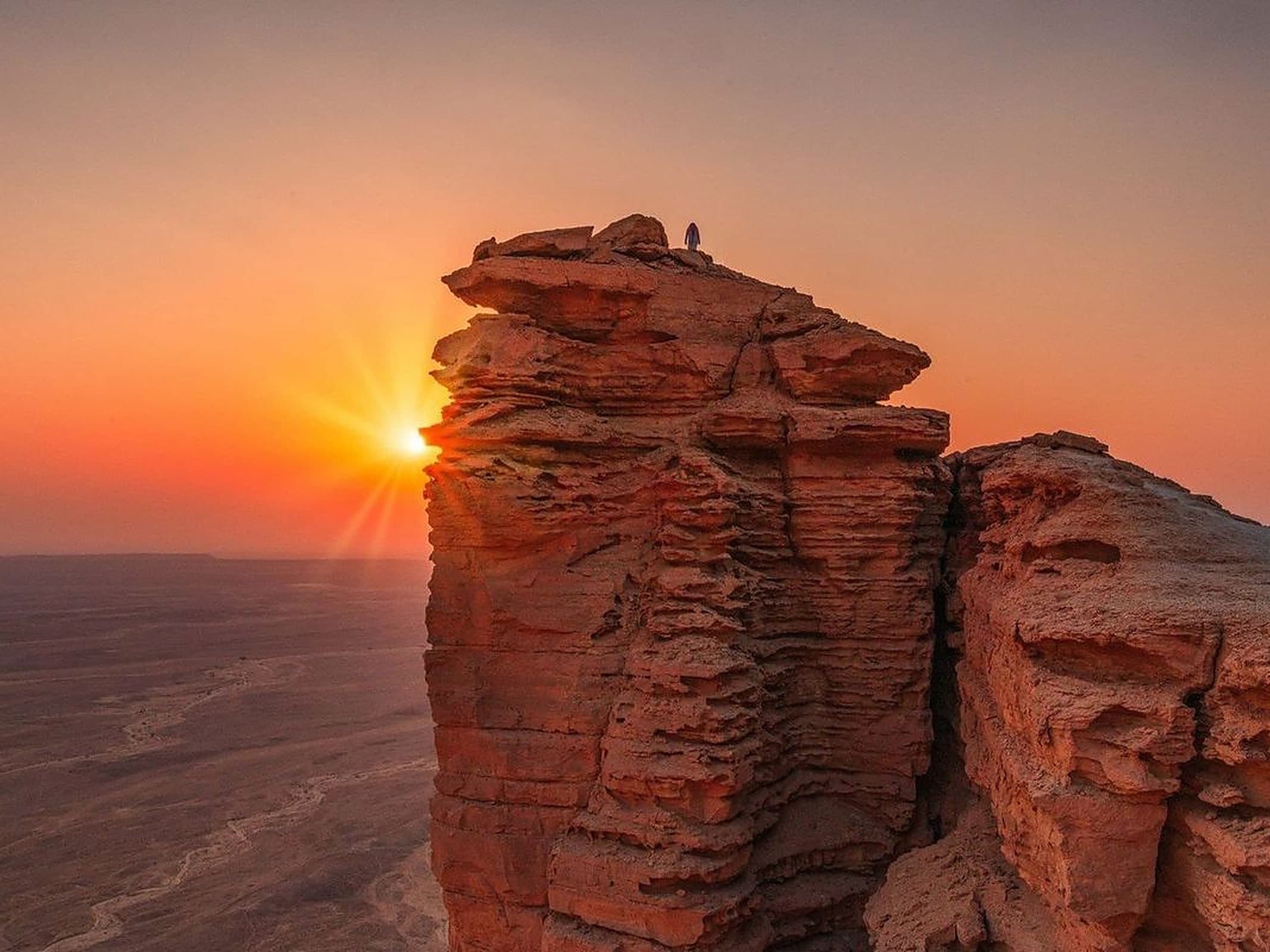 Riyadh sightseeing tour, a lone figure on the Edge of the World cliffs at sunset outside Riyadh