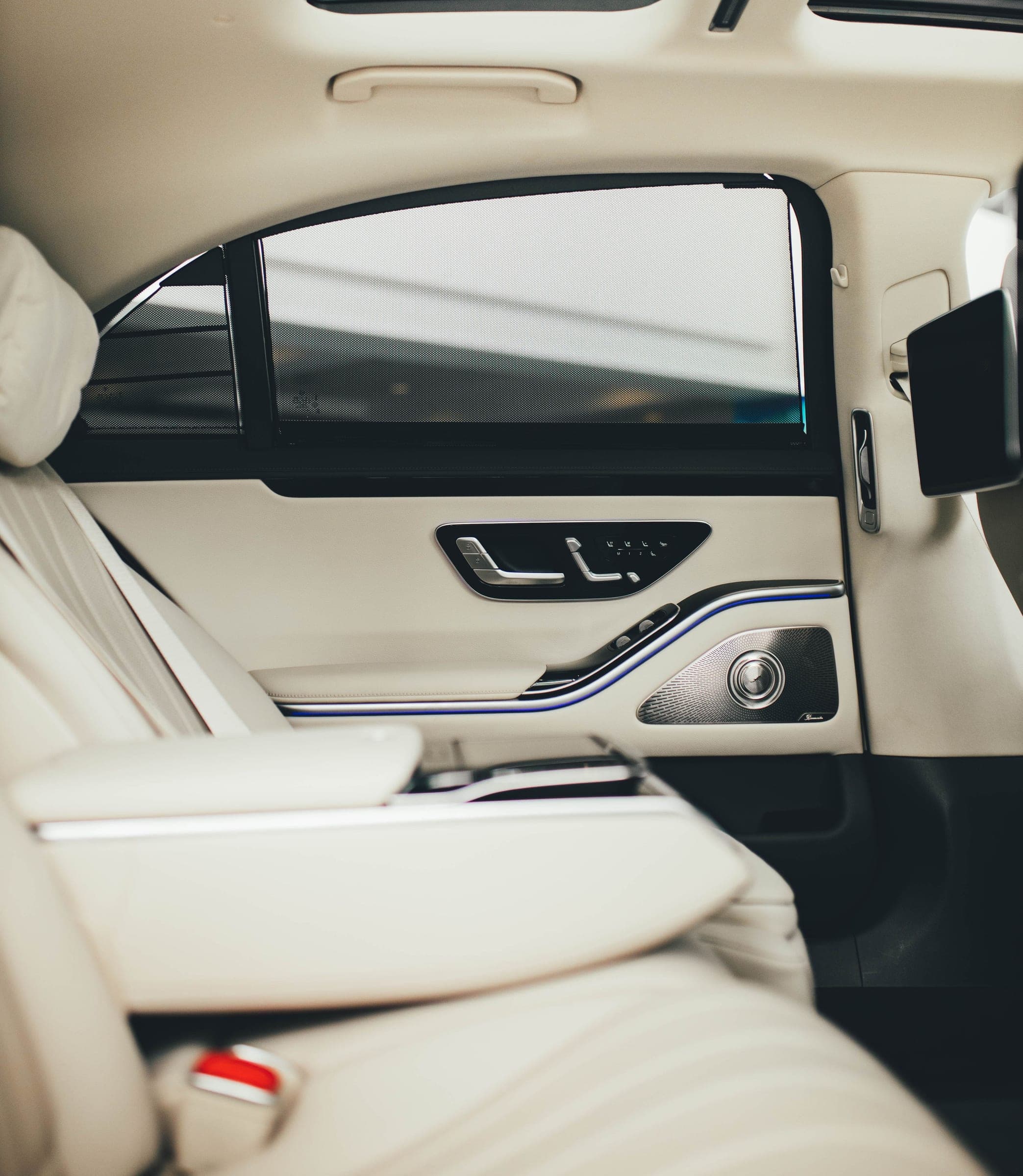 The quiet rear cabin of a Mercedes S-Class with the window blinds drawn, held for a principal on VIP concierge work in Riyadh