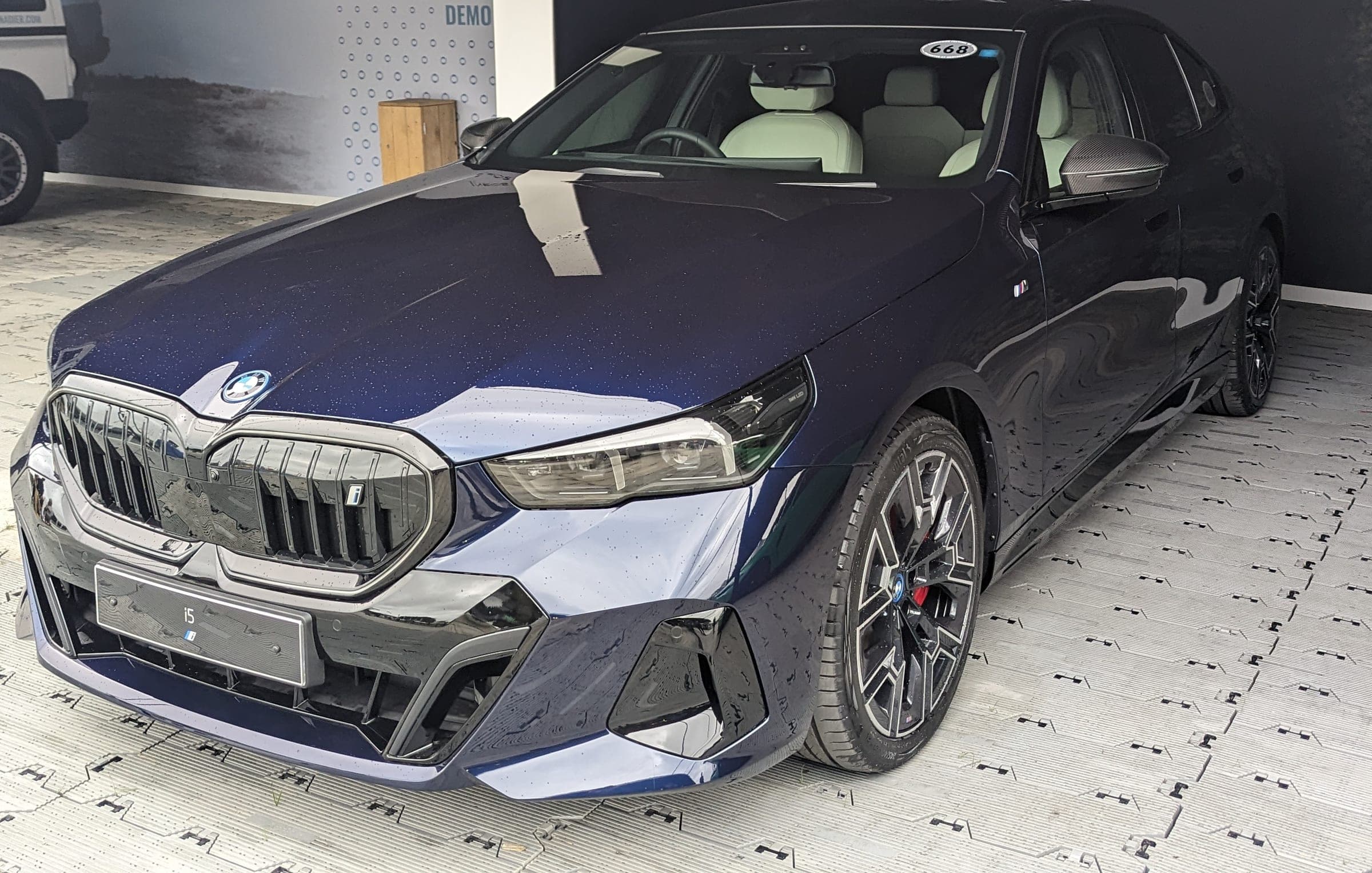 BMW i5 in dark blue on the show floor, the current G60 generation