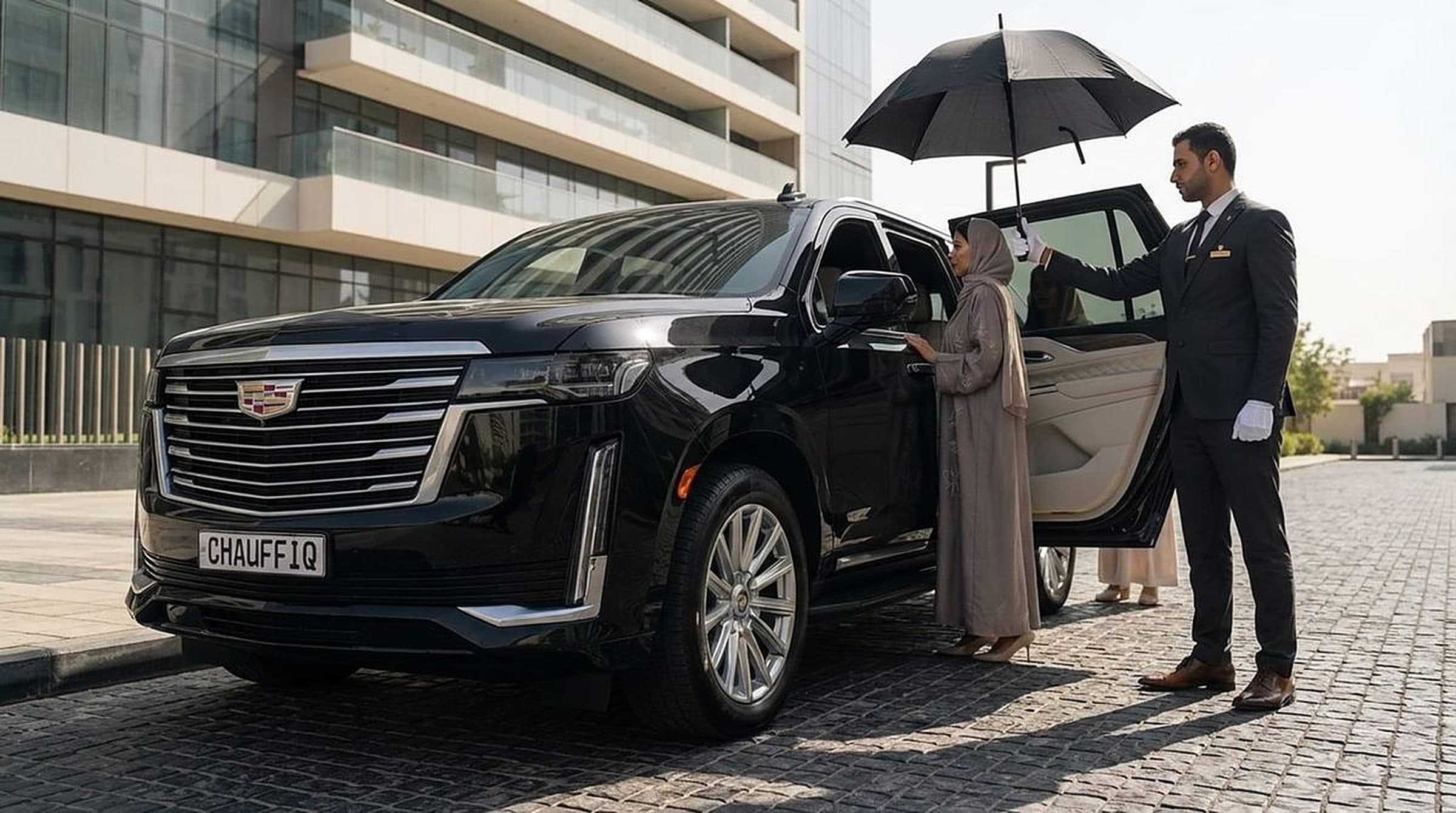 CHAUFFIQ chauffeur holding the Escalade's rear door open for a guest