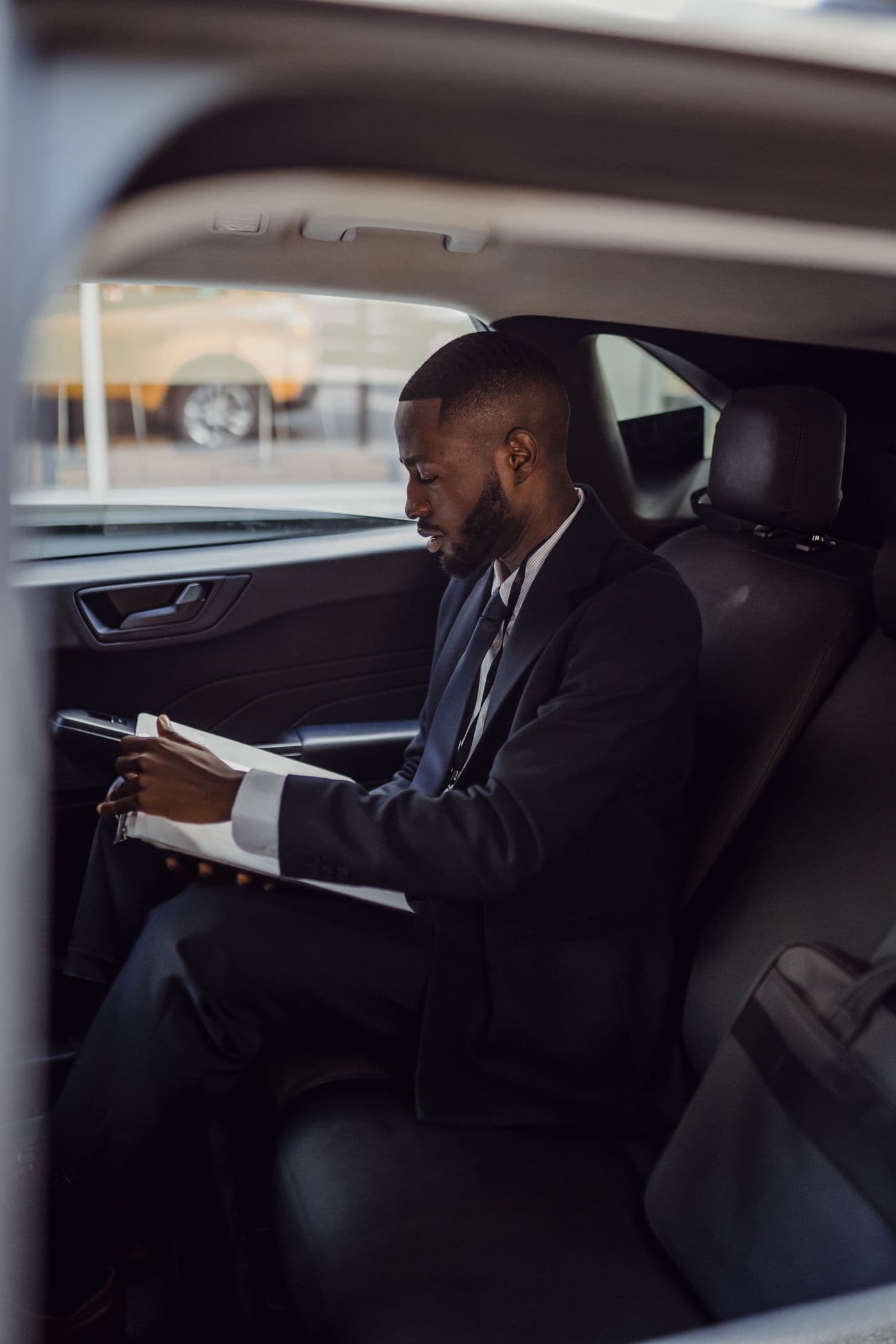 Passenger working from the rear seat of a dark executive cabin