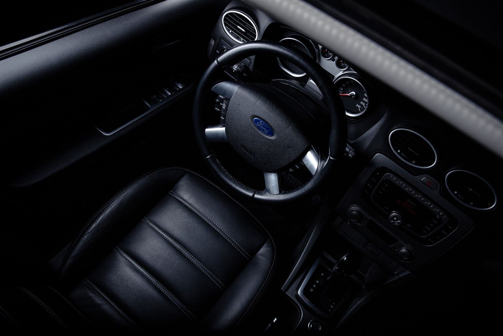 Black Ford cabin in low light, leather seats and dark trim