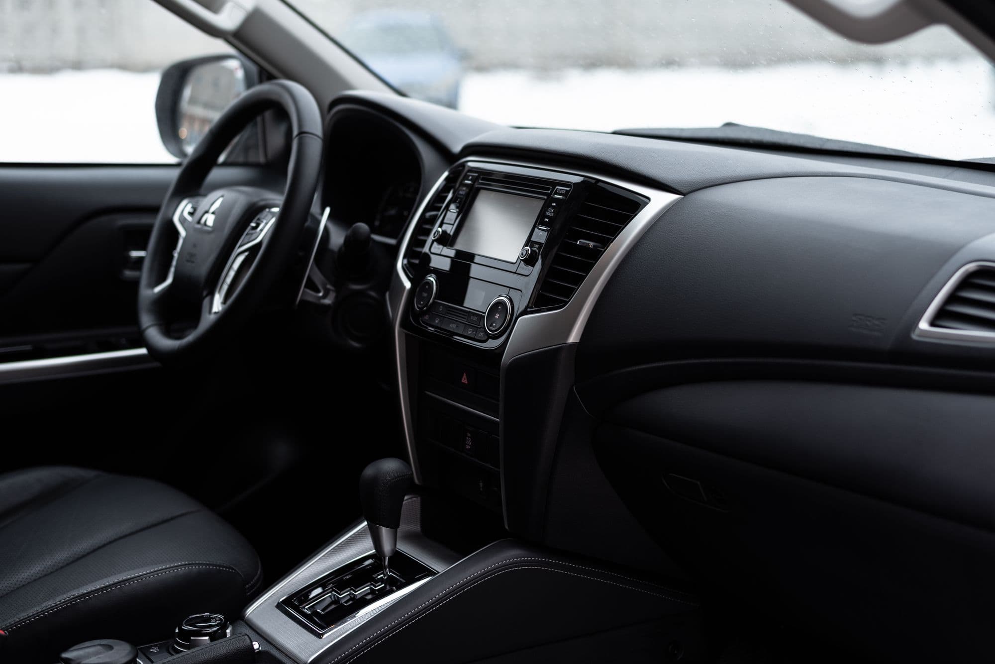 Full-size SUV cockpit in black, gear selector and centre console in view