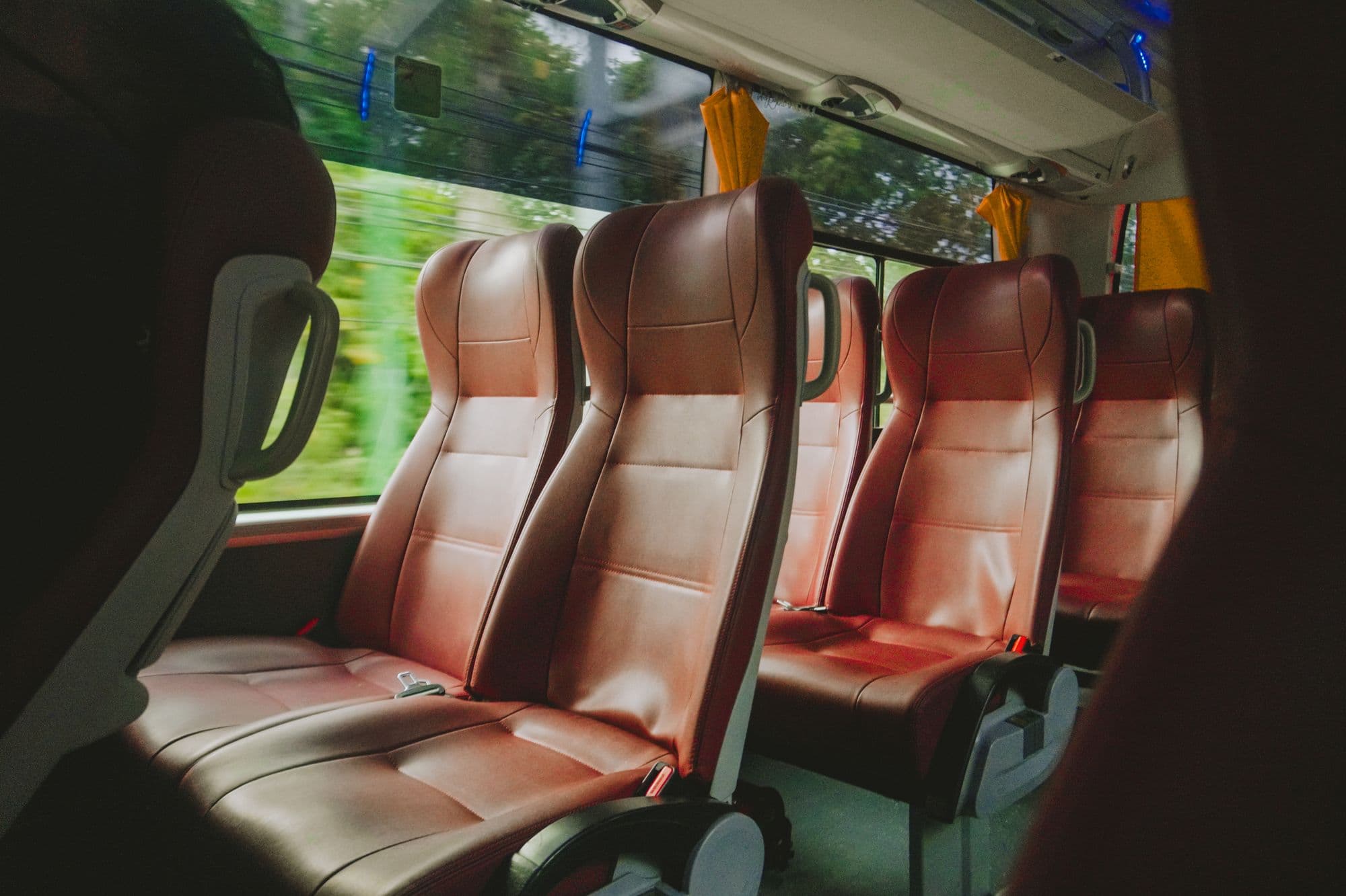 Minibus passenger rows in soft leather, headrests down the aisle
