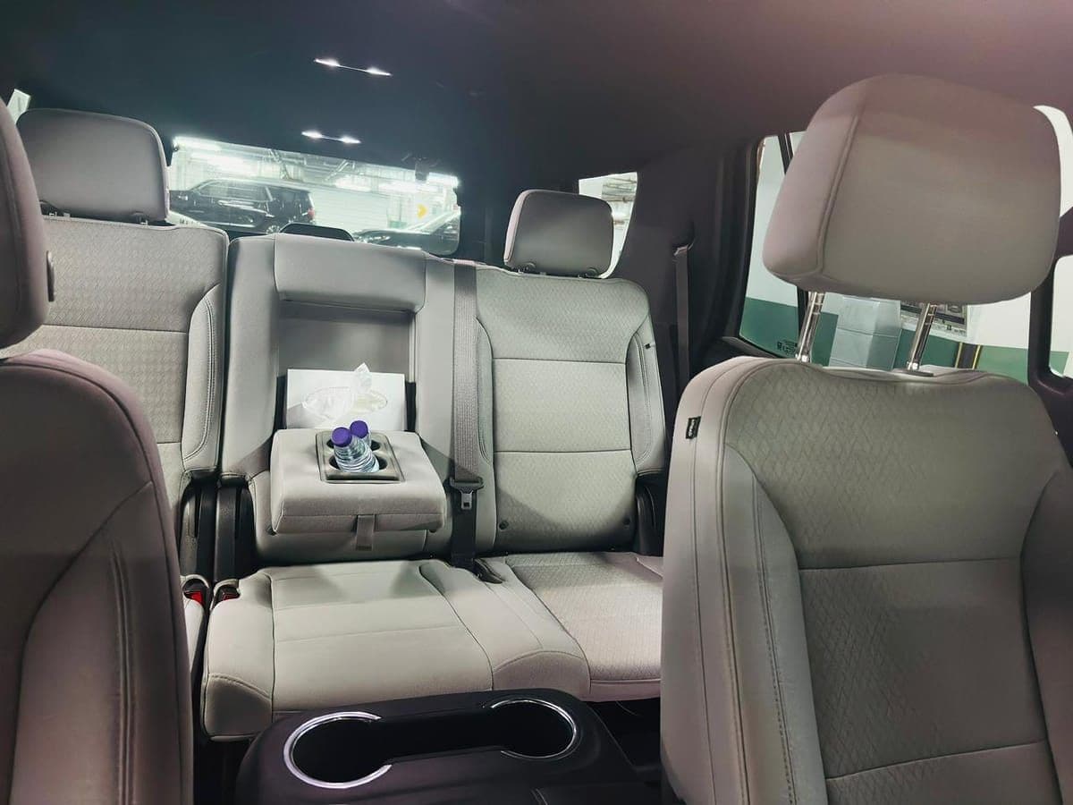 Middle row of a CHAUFFIQ own-fleet SUV, stocked with water and tissues