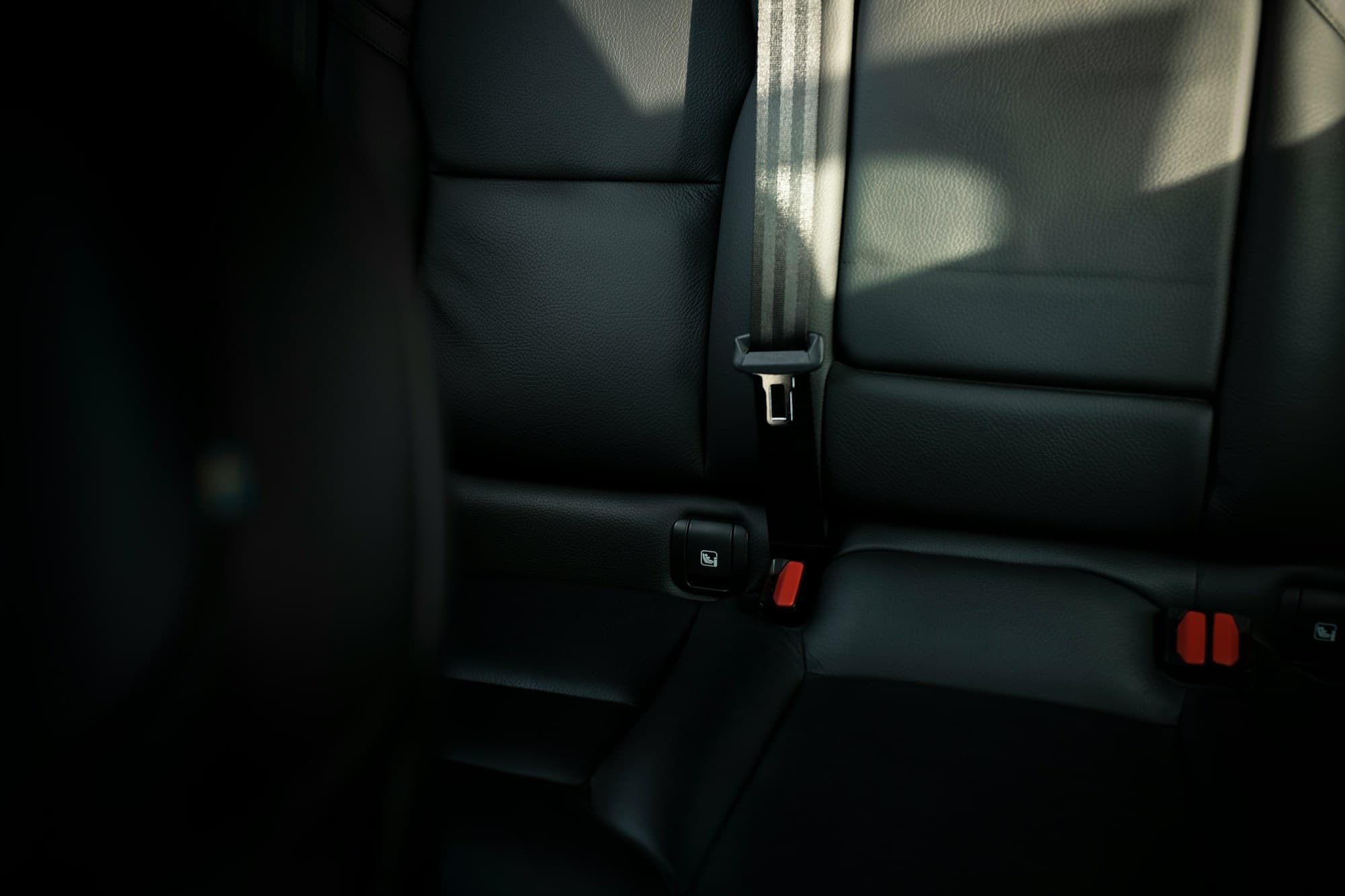 Black leather rear bench with the belt drawn across it