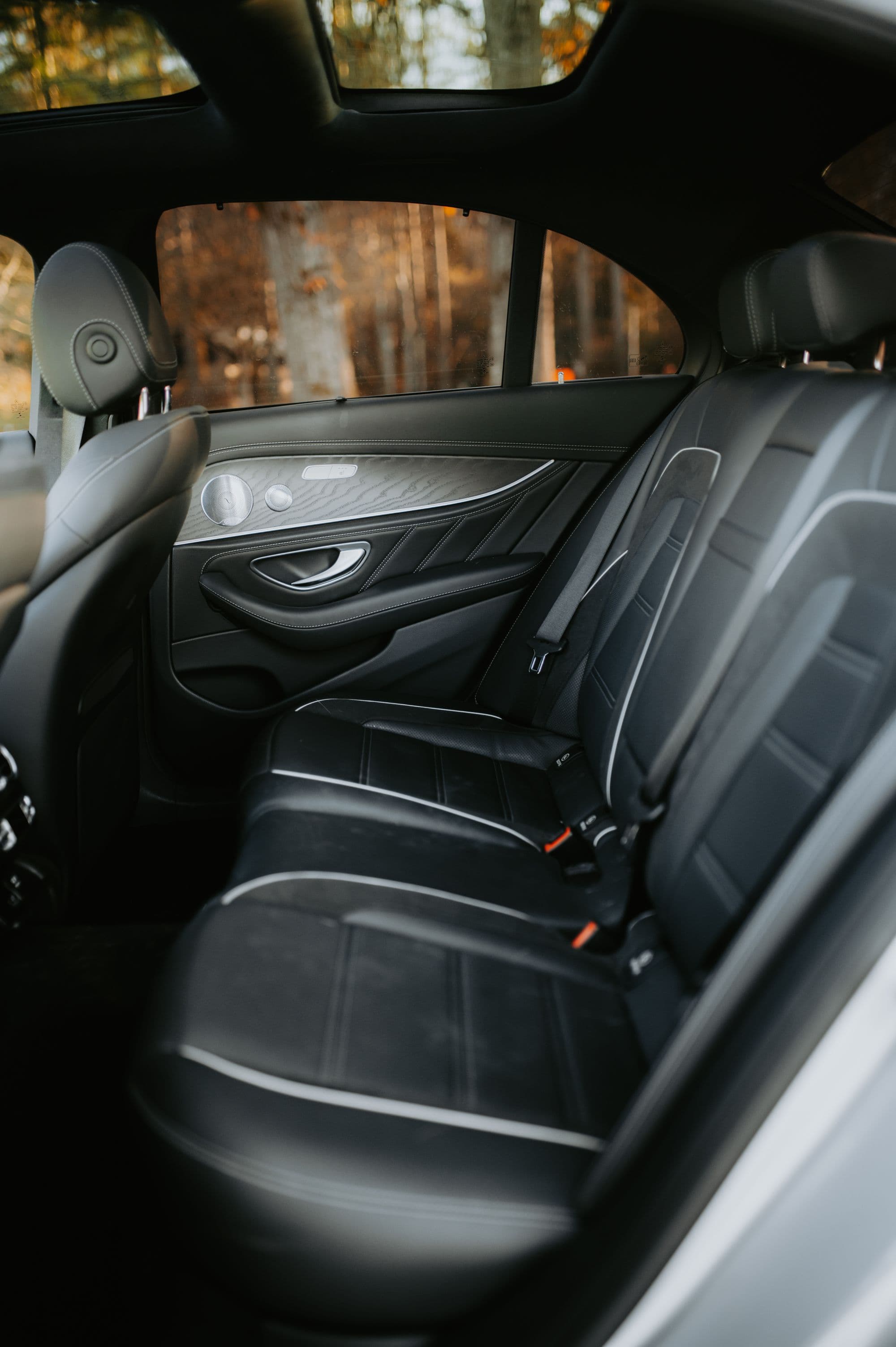 Black leather rear seats with the door open onto the cabin