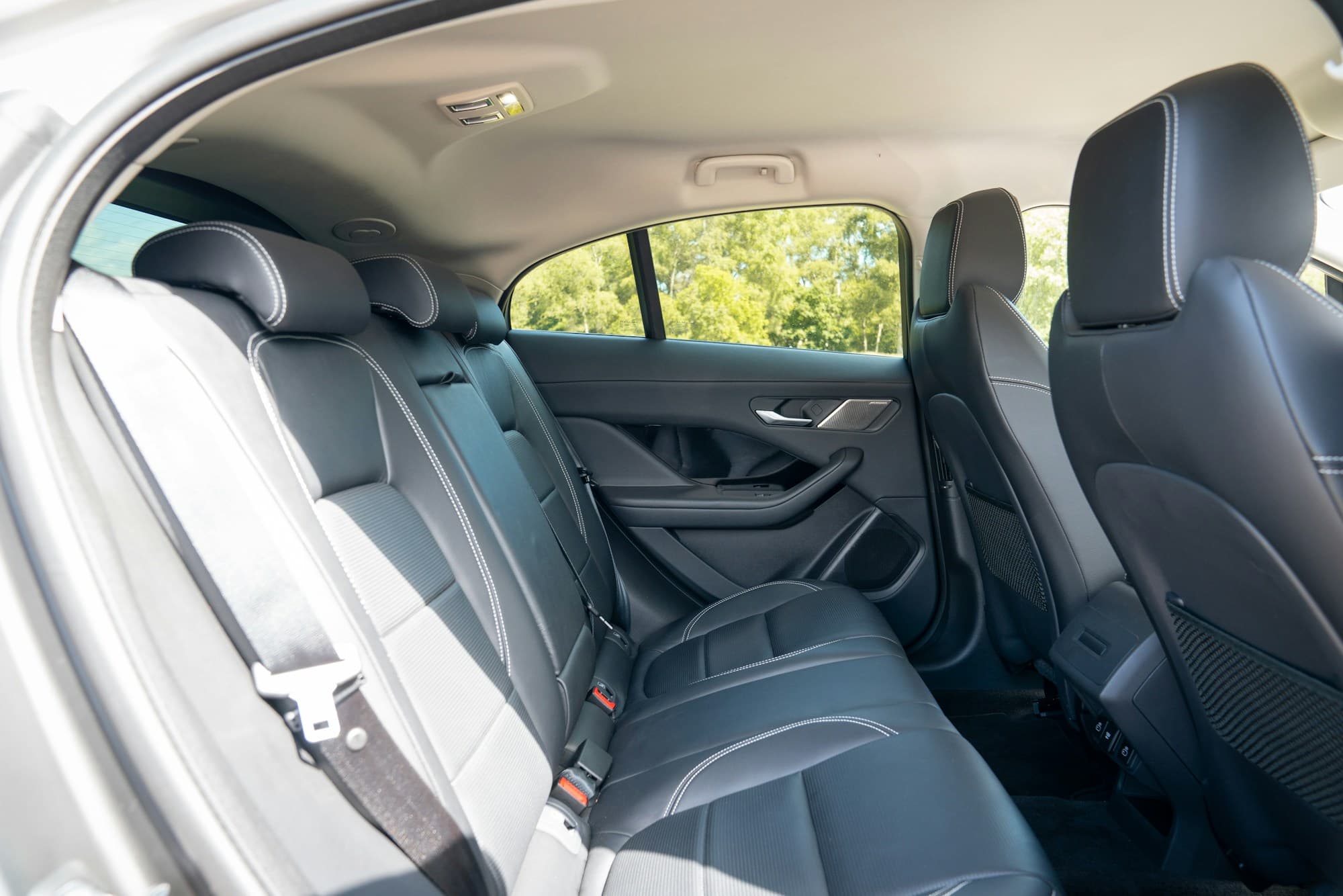 Black rear seats of a passenger van, belts fitted at every place