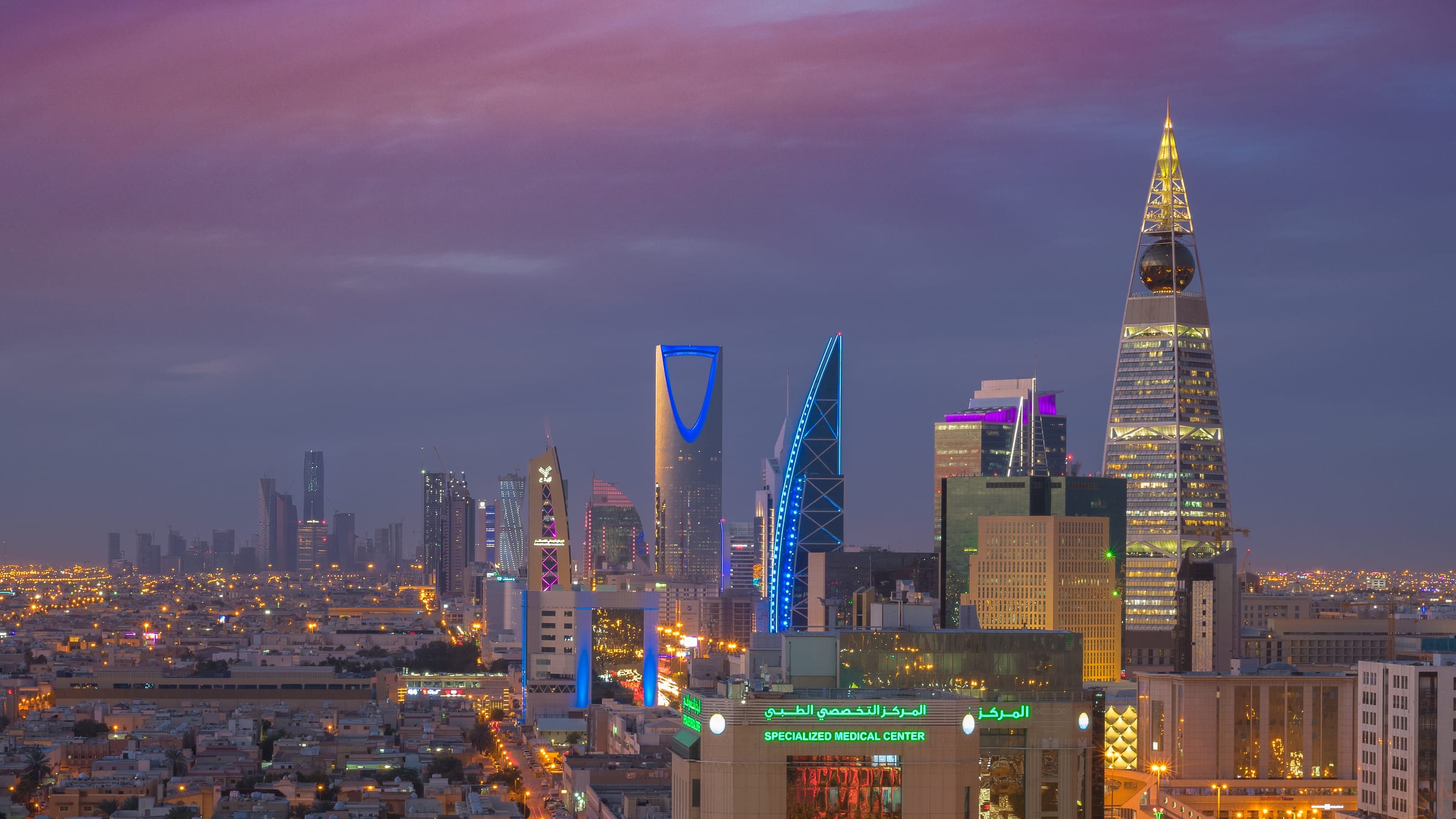 The Riyadh skyline at dusk, Kingdom Centre and Al Faisaliah Tower lit against the evening sky