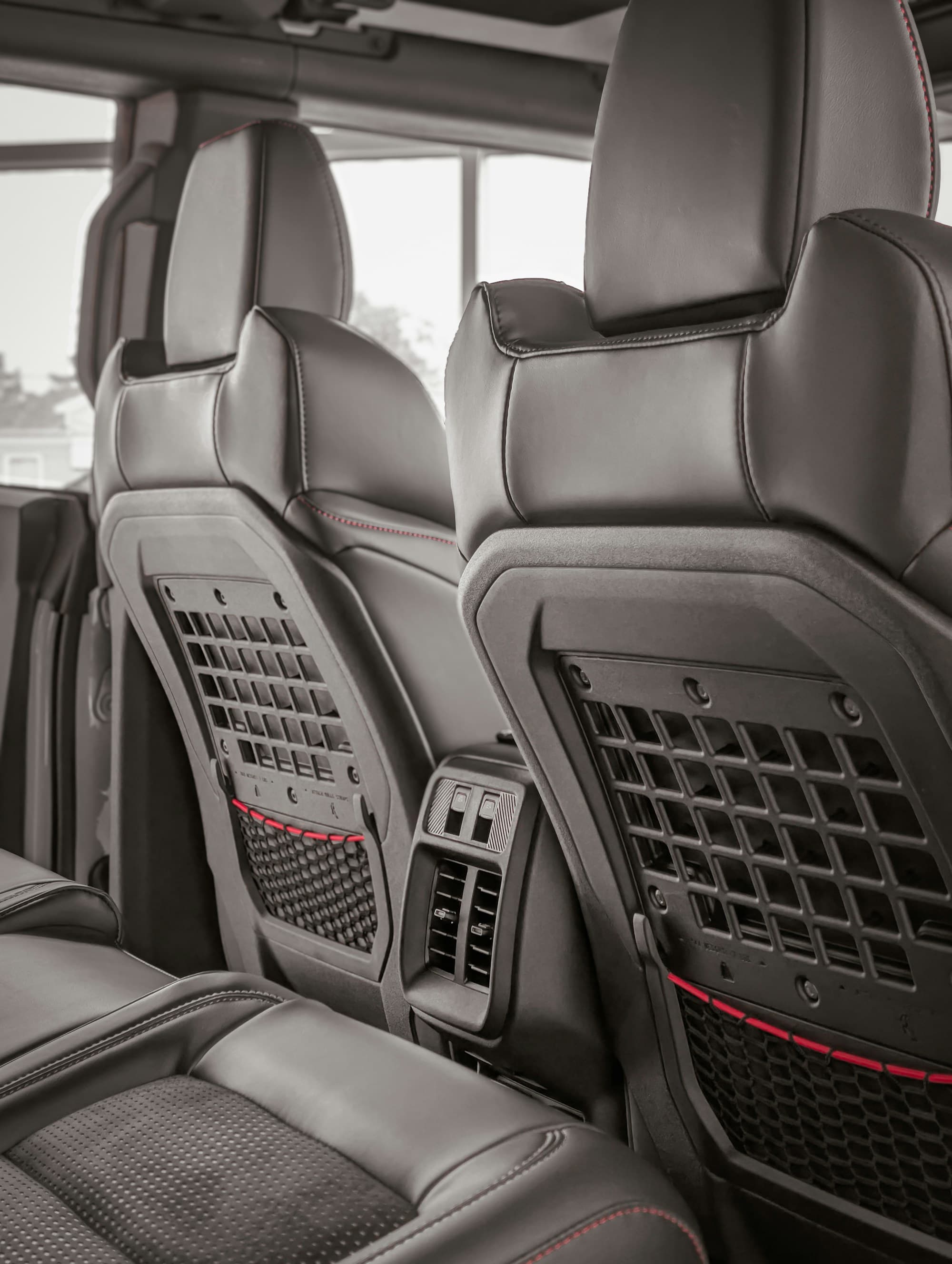 Black seat backs with storage pockets, seen from the rear seat
