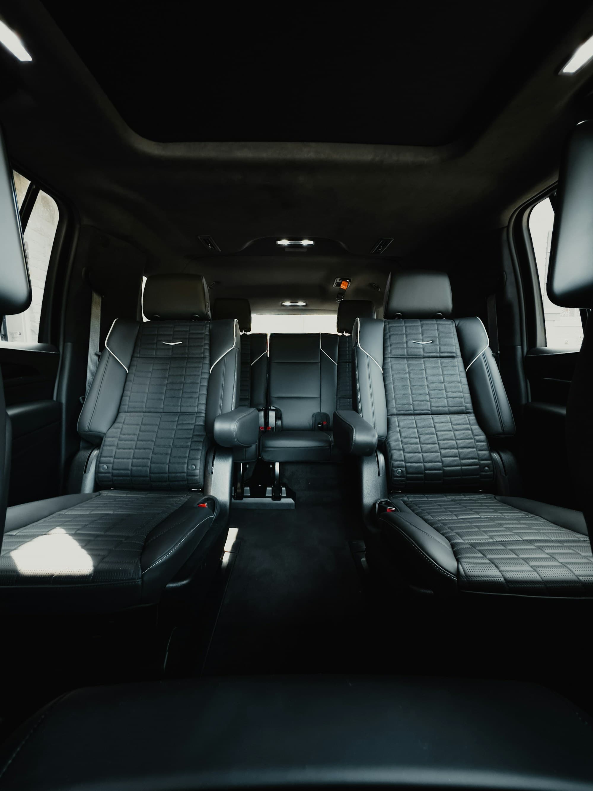 Black quilted captain armchairs either side of the aisle