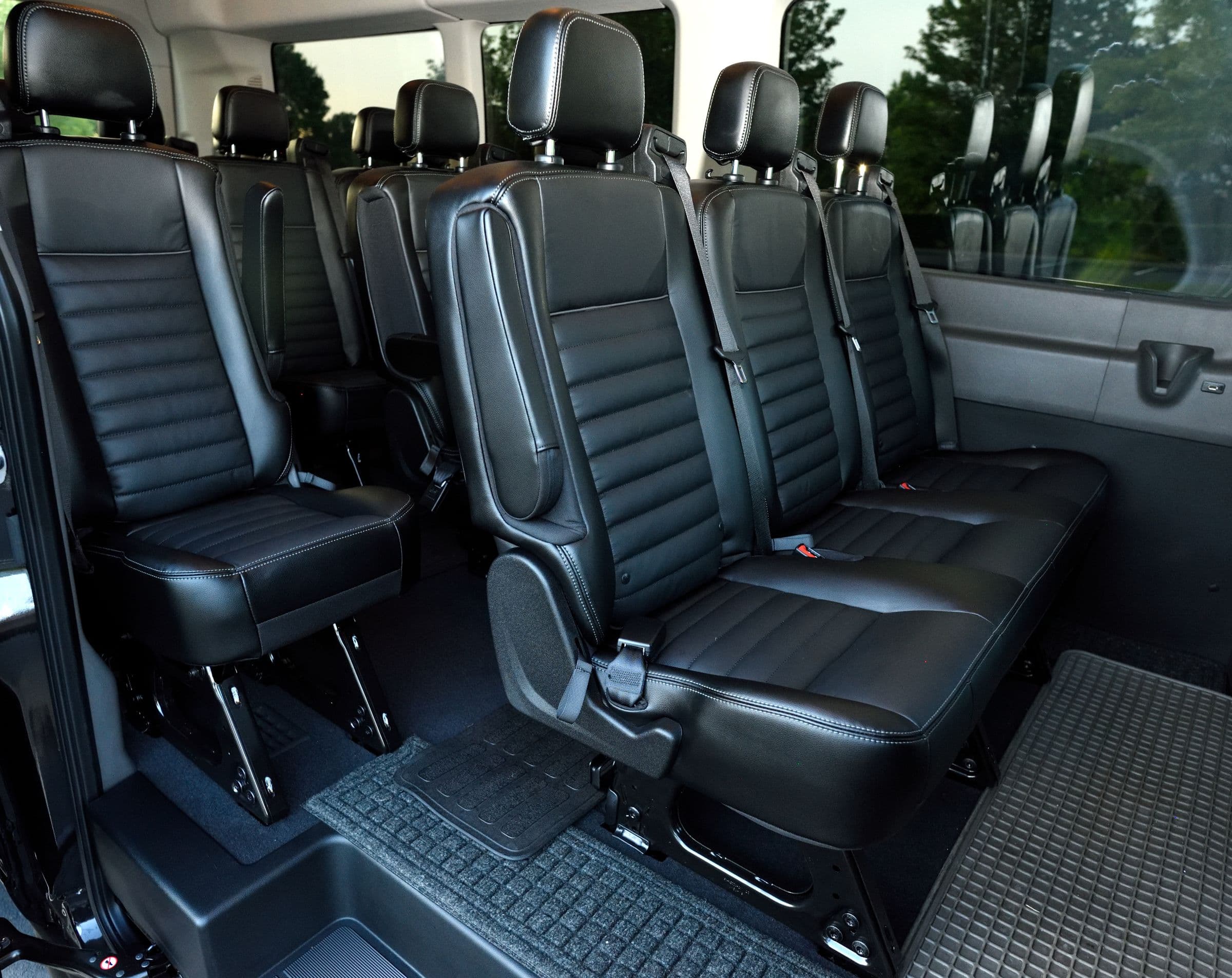 Van cabin in black leather, rows either side of the aisle