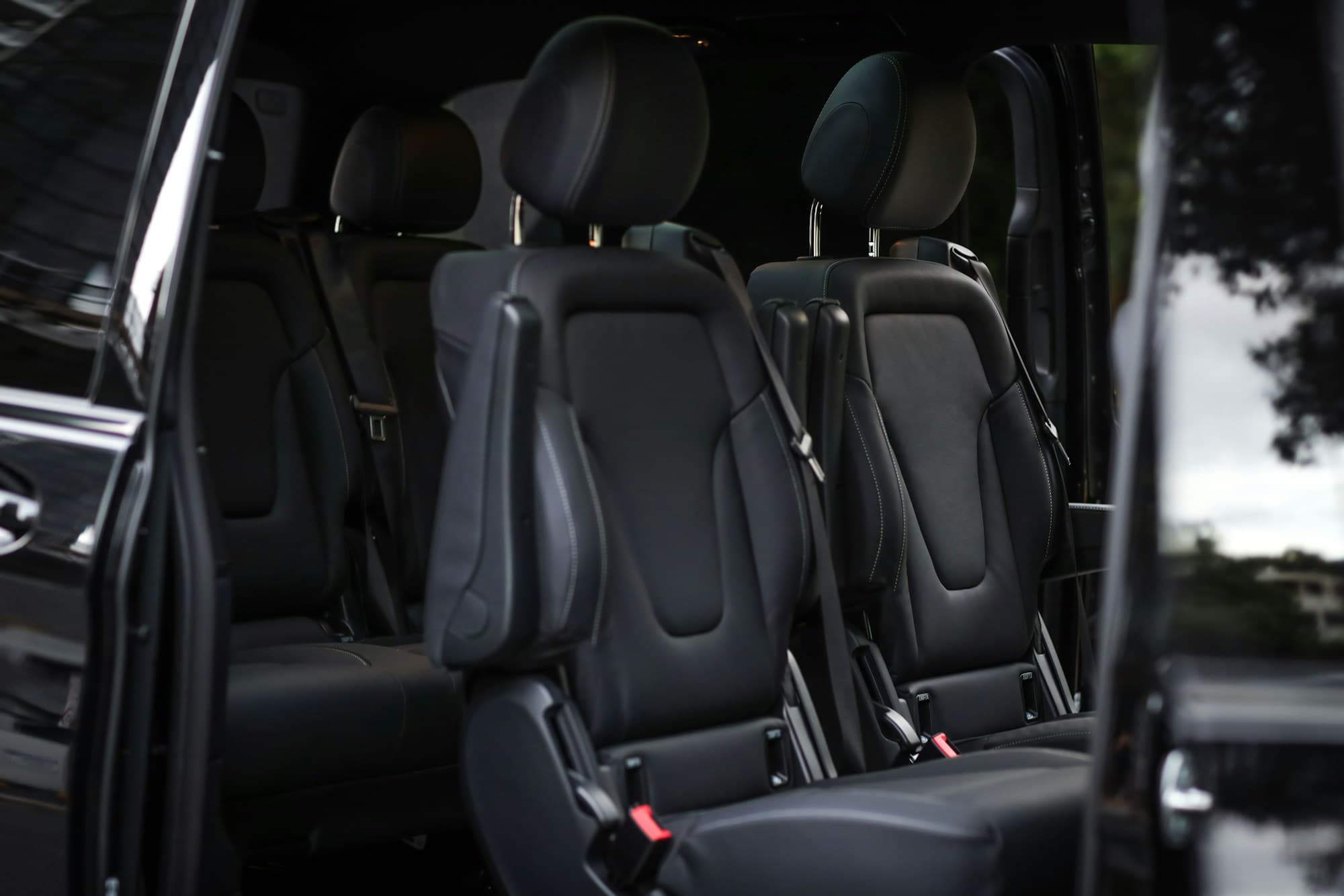Van cabin in black leather, seats seen down the aisle