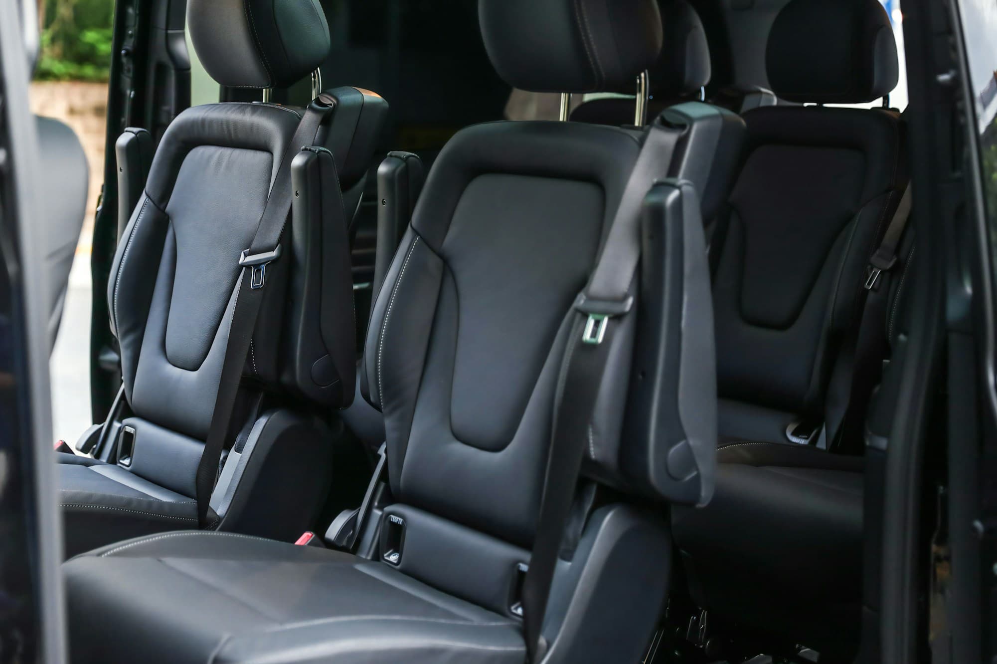Van passenger seats in black leather with belts at every place